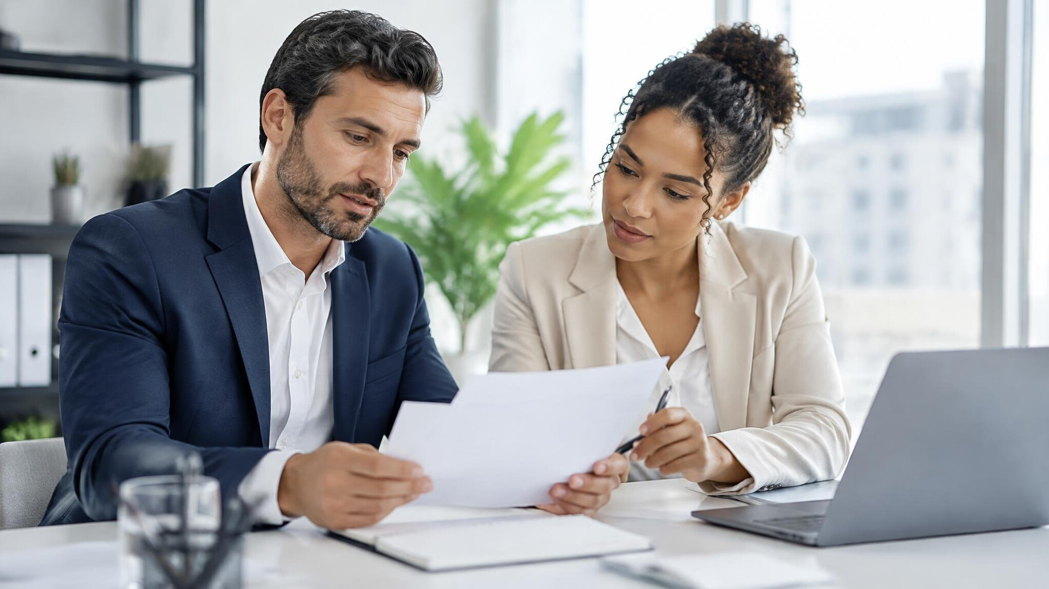 Two colleagues discussing documents in an office